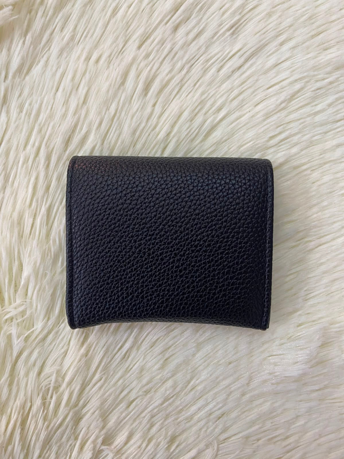 Monedero pequeño negro con diseño al frente en color dorado, cierre de boton y súper espacioso.