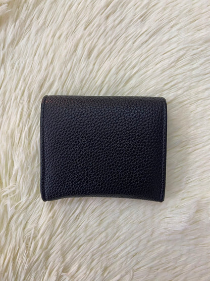 Monedero pequeño negro con diseño al frente en color dorado, cierre de boton y súper espacioso.