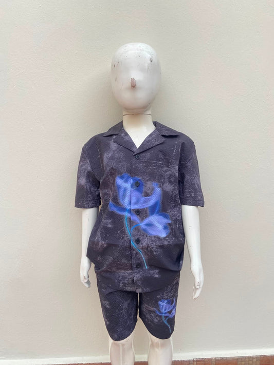 Conjunto camisa manga corta y short, color gris con degradado y detalle de flor azul.