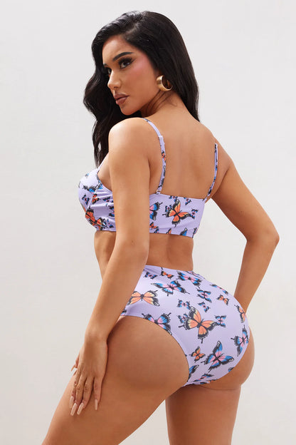 Biquini, de dos piezas morado con estampado de mariposas en color naranja.
