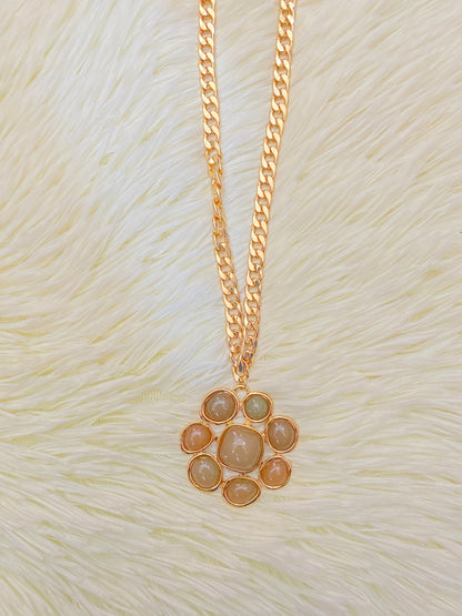 Cadena, dorada con dije en forma de flor y piedras verde.