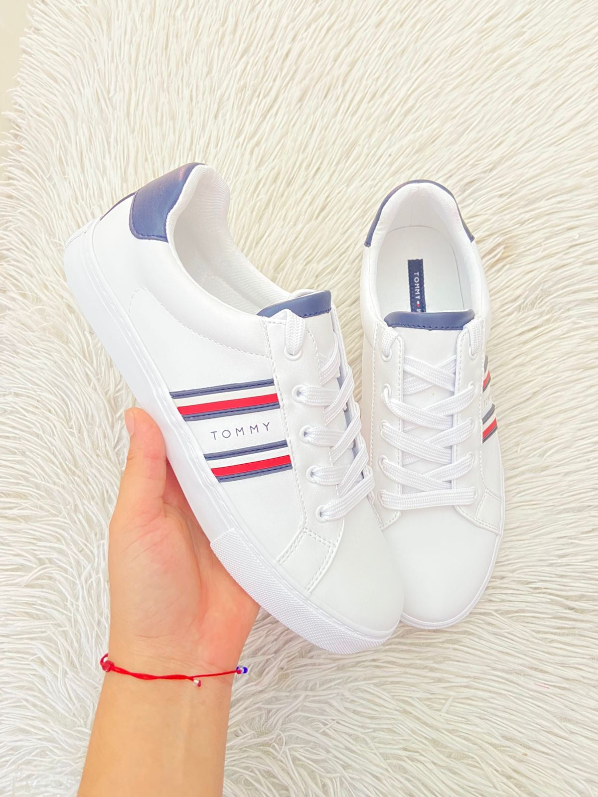 Tenis Tommy Hilfiger Original en color blanco con bandera de la en los lados y letra Tommy en el medio