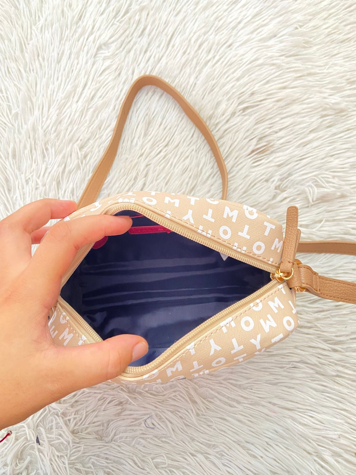 Cartera TOMMY HILFIGER original crema con estampado de letras TOMMY y banda de color rojo, azul y blanco y placa TH en dorado.