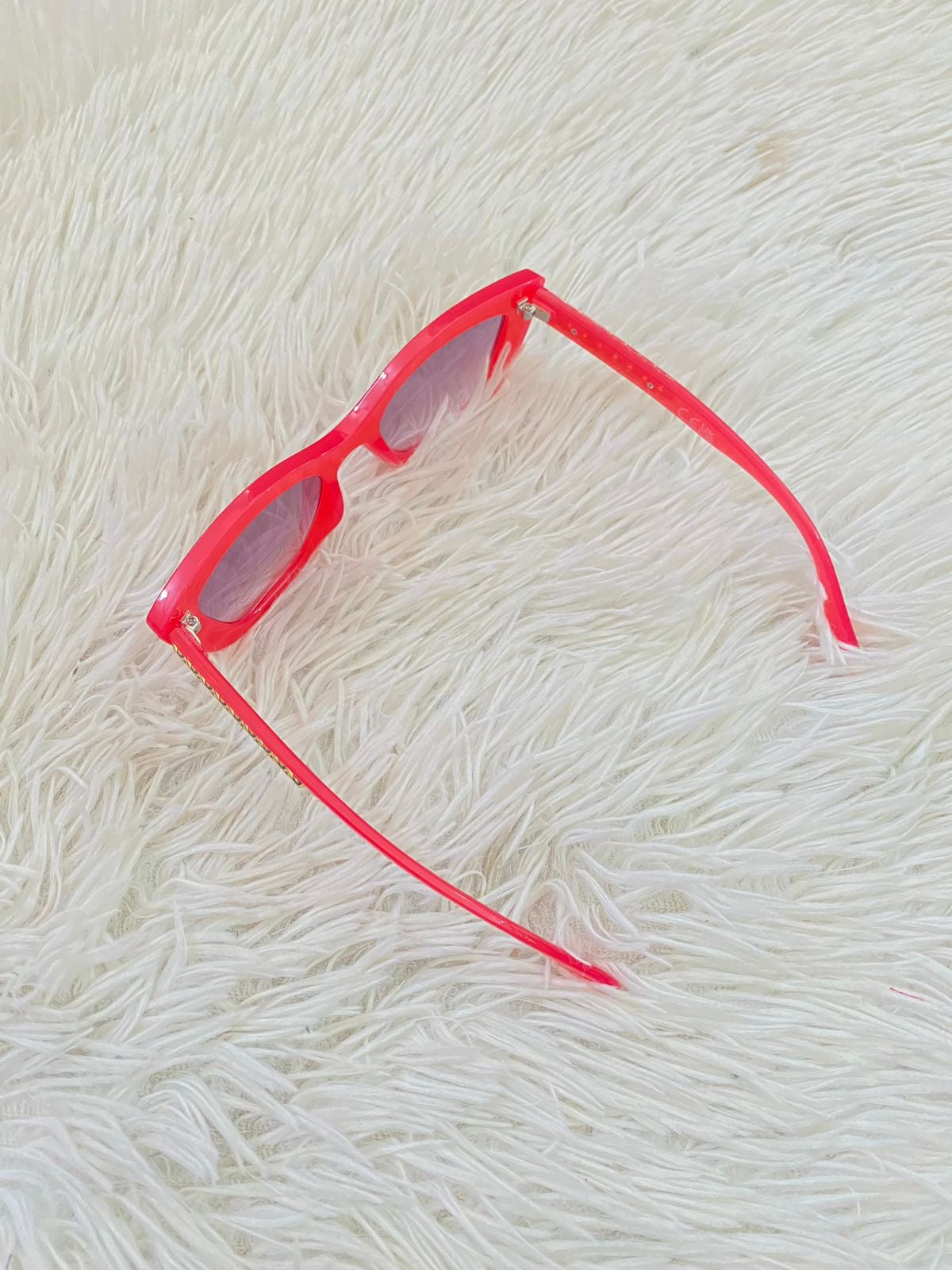 Lentes Fashion Nova original rosado salmón con detalles de cadena dorado atrás.