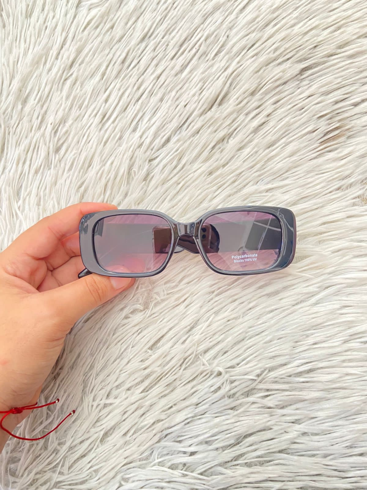 Lentes, negro con micas claras y montura en color negro y detalles en color dorado.