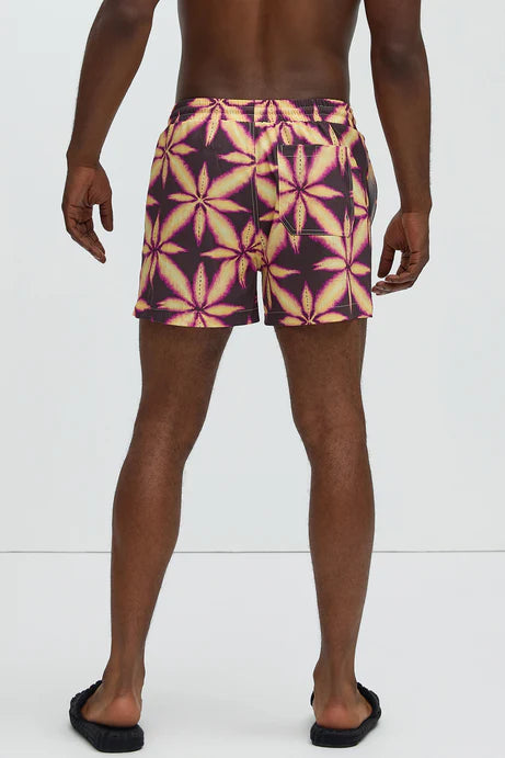 Bañador Baggy morado con estampado de una hoja amarilla.