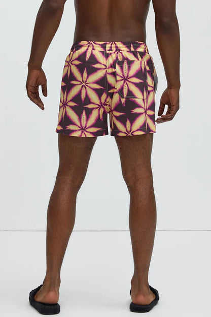 Bañador Baggy morado con estampado de una hoja amarilla.