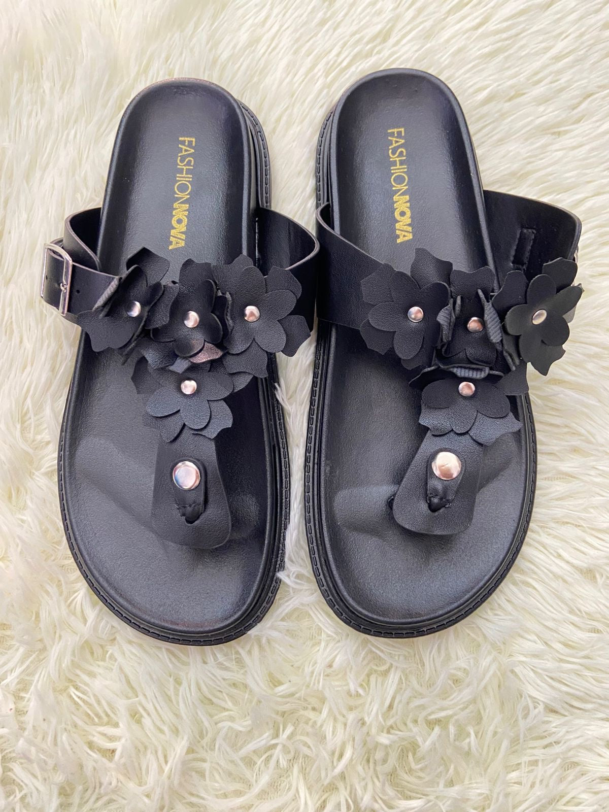Sandalias, negra con flores en frente y correa ajustable.
