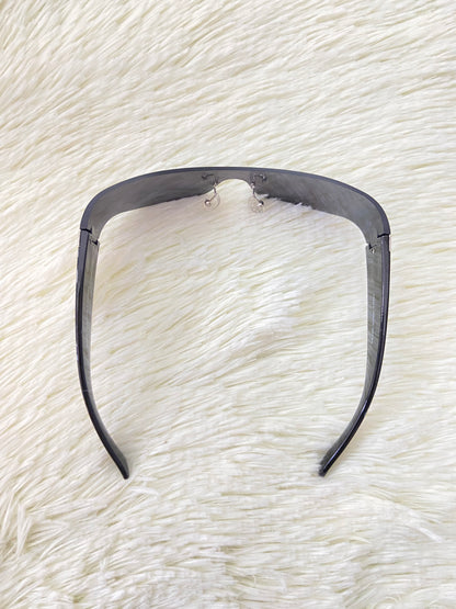 Lentes, negros curvos con detalles plateados en la montura.