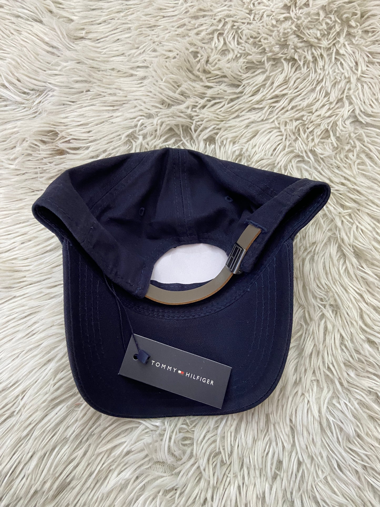 Gorra Tommy Hilfiger original azul marino, con letras TOMMY HILFIGER en blanco y correa marrón.