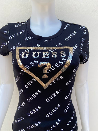 T-shirt GUESS original, negro con estampado de otras GUESS en blanco y triángulo en dorado con su logo.