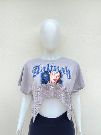 Crop-top gris con encaje abajo y estampado de la palabra Aaliyah en color azul y imagen.