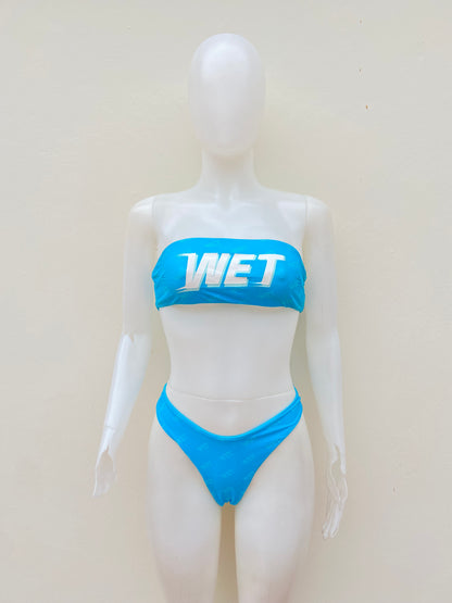 Biquini, azul claro con letras WET en blanco, strapless, 2 piezas.