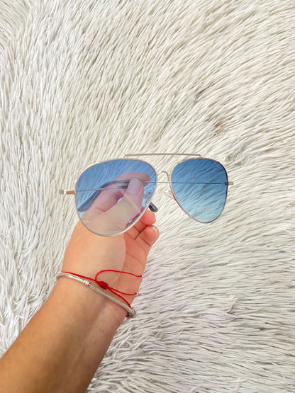 Lentes diseñados con protección UV 100-400 para proteger tu visión. Con montura plateada y micas azules