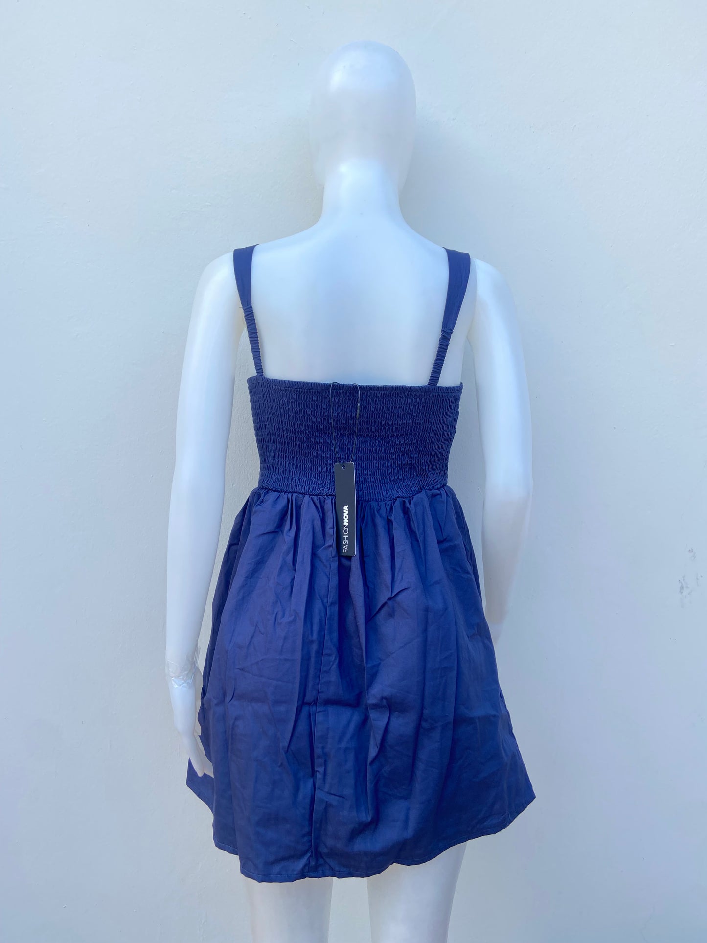 Vestido, algodón orgánico en azul marino ( NAVY) con flor rosada en frente.