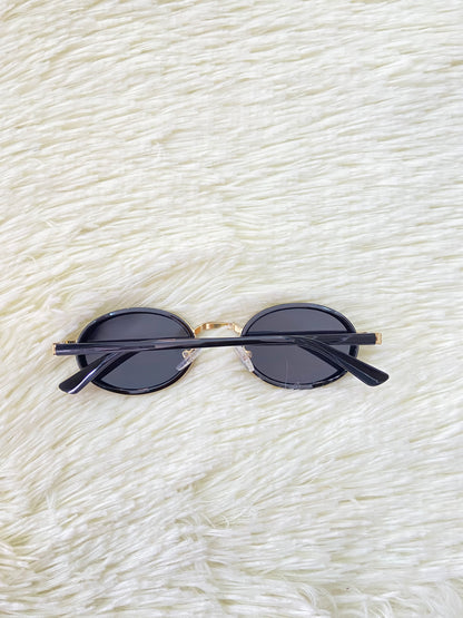 Lentes, negros con montura dorada ovalados, con protección UV 100% Polycarbonate.