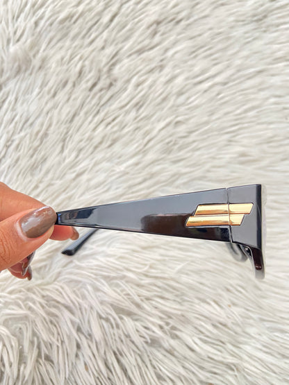 Lentes, diseñados con protección UV 100-400 para proteger tu visión. Negro con micas en color morado/ azul y detalles dorado.