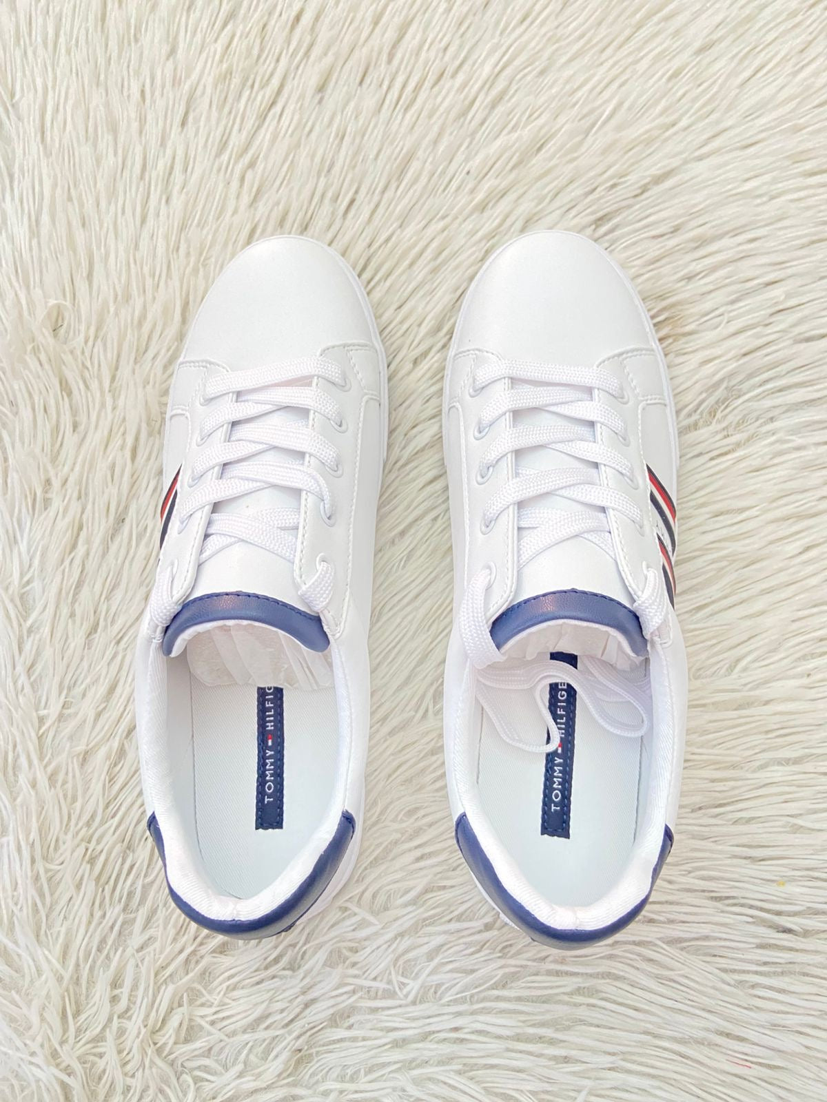 Tenis Tommy Hilfiger Original en color blanco con bandera de la en los lados y letra Tommy en el medio