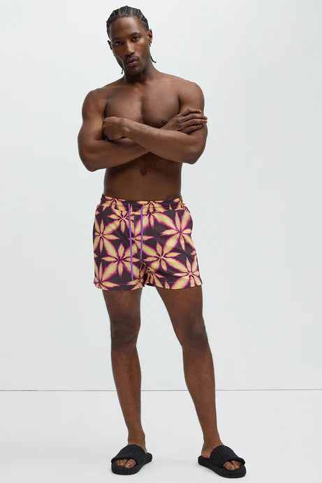 Bañador Baggy morado con estampado de una hoja amarilla.
