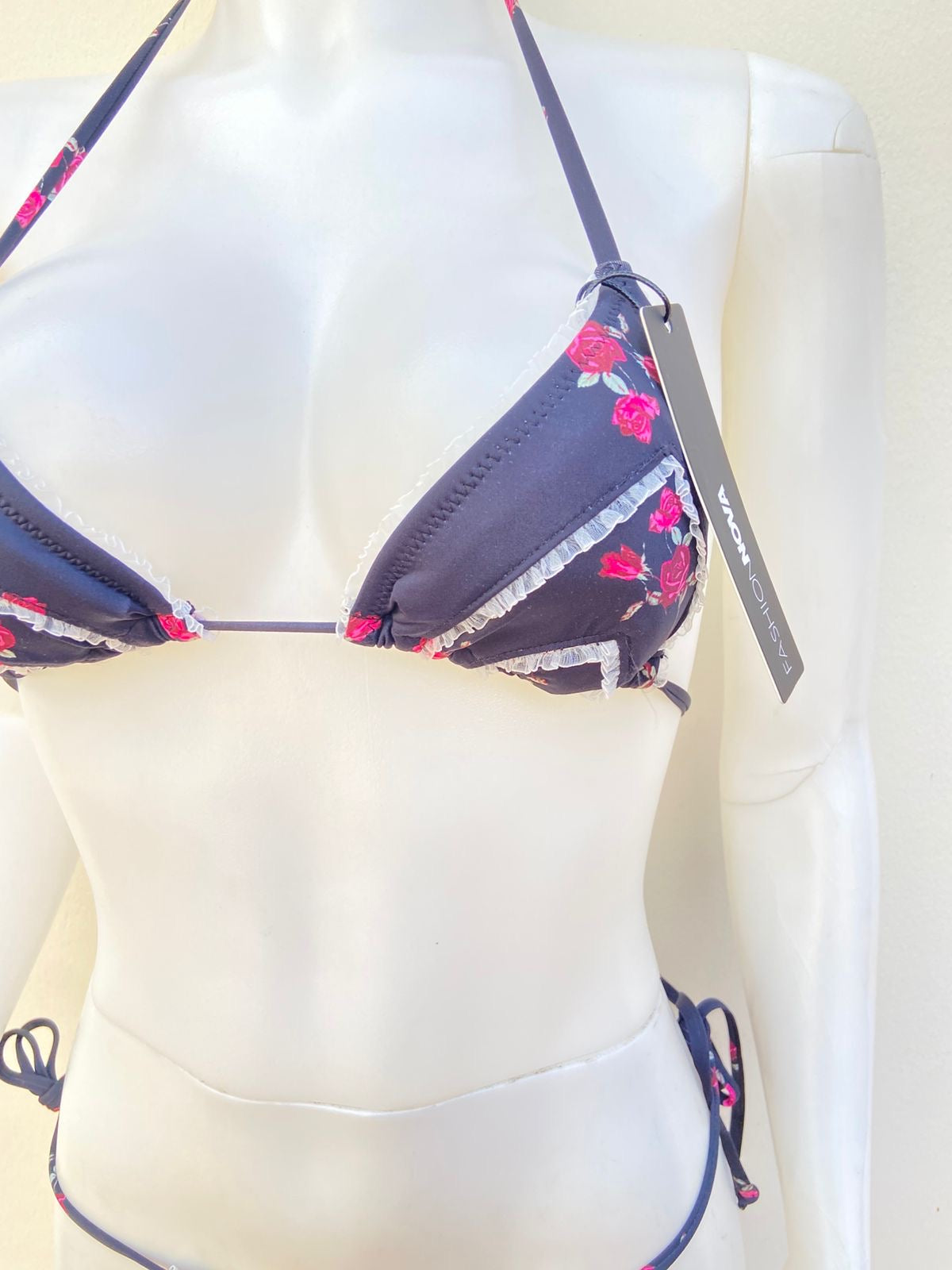 Biquini, negro con estampado de flores y encaje en color blanco.