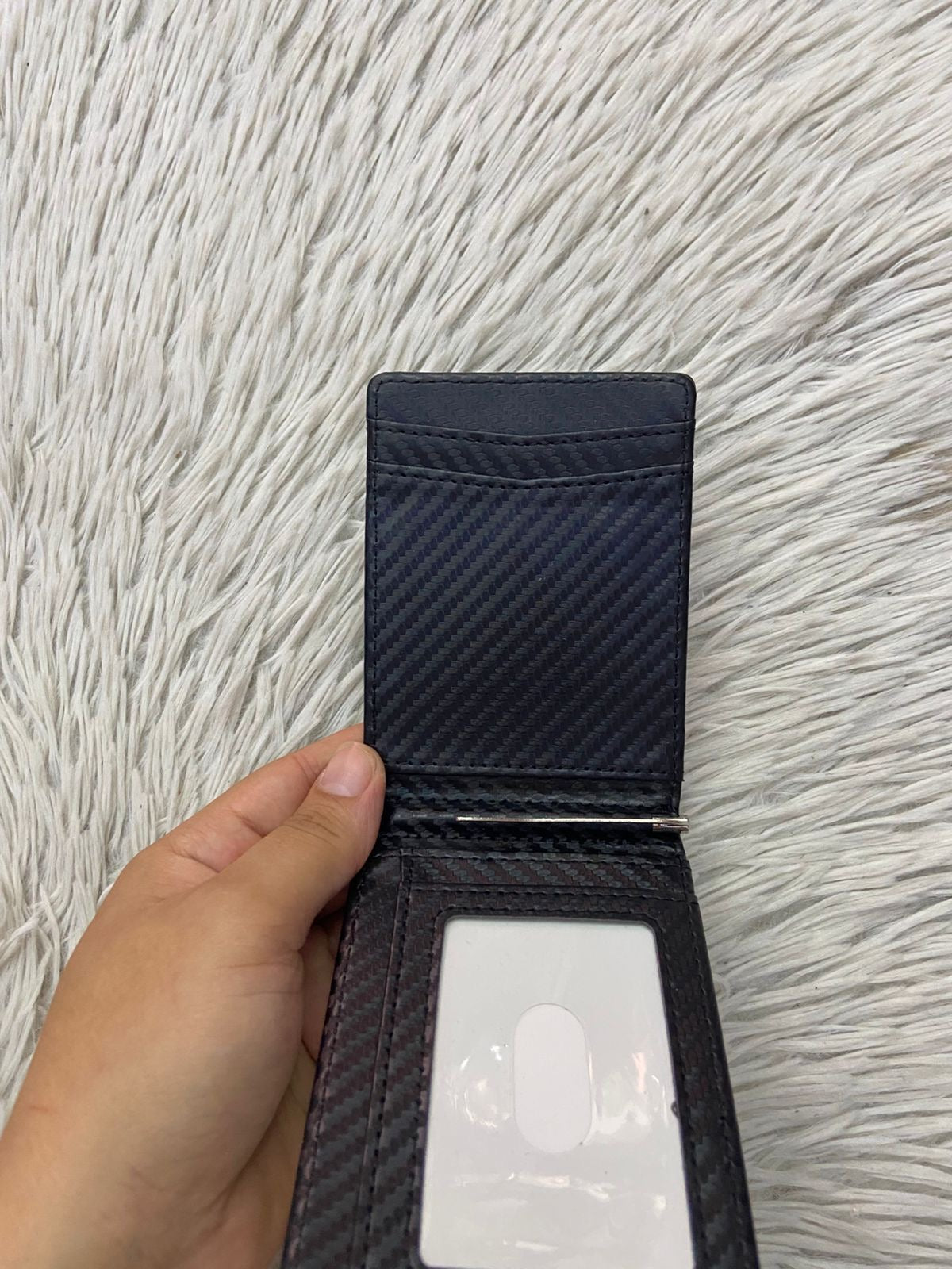 Billetera pequeña en color negra con clip para billetes, espacios para tarjetas y espacio transparente para cedula o licencia.