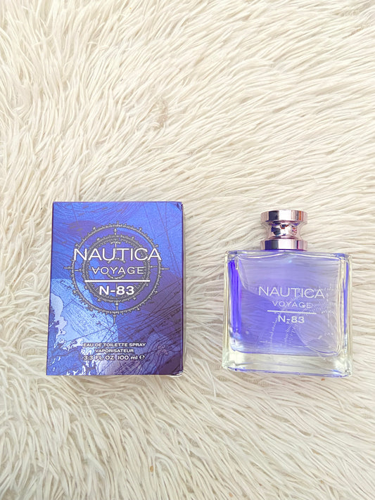 Perfume NAUTICA VOYAGE N- 83 original, azul marino con fondo de una brújula.