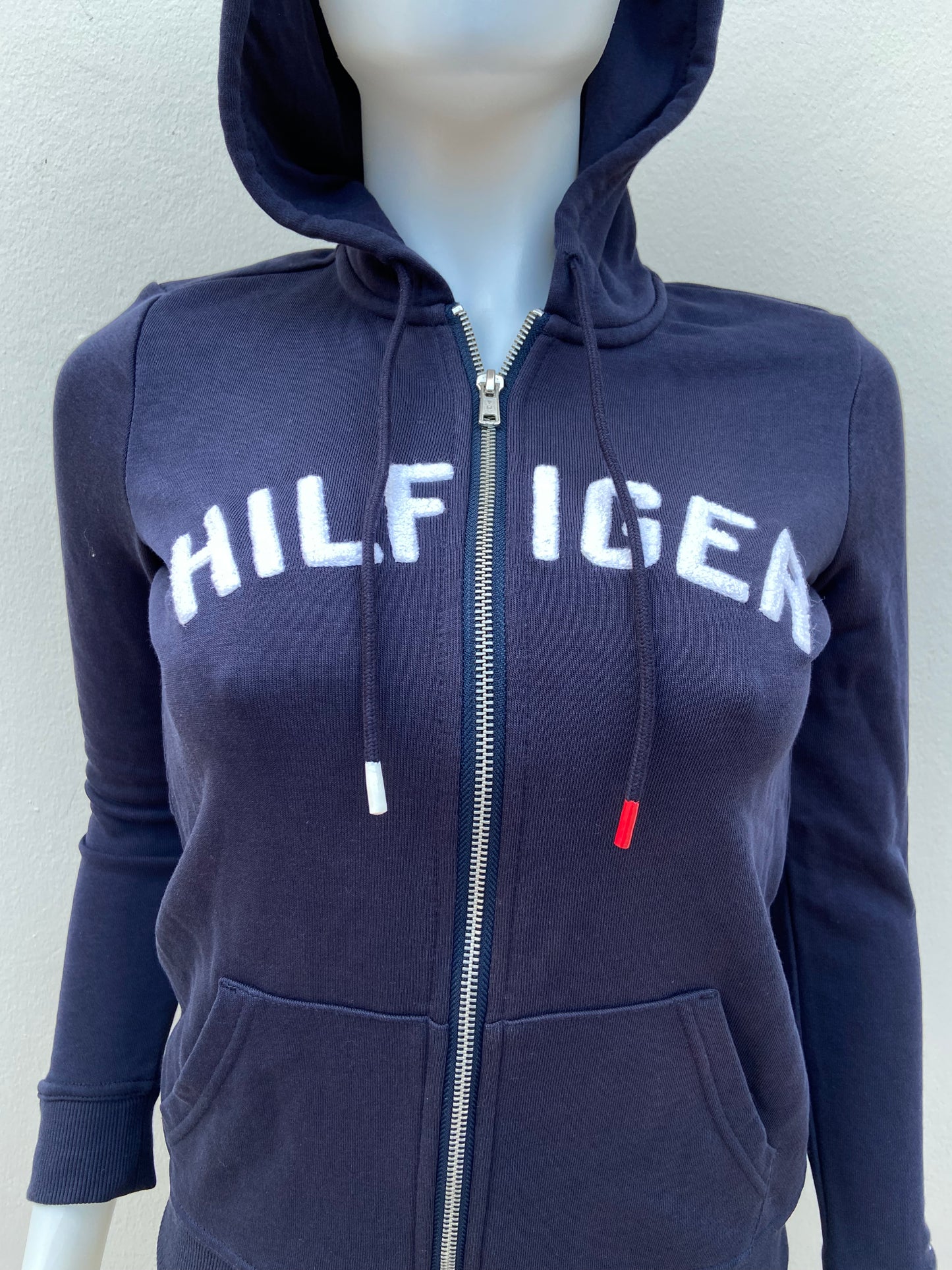 Abrigo Tommy Hilfiger original azul marino con zíper y letras HILFIGER en blanco.