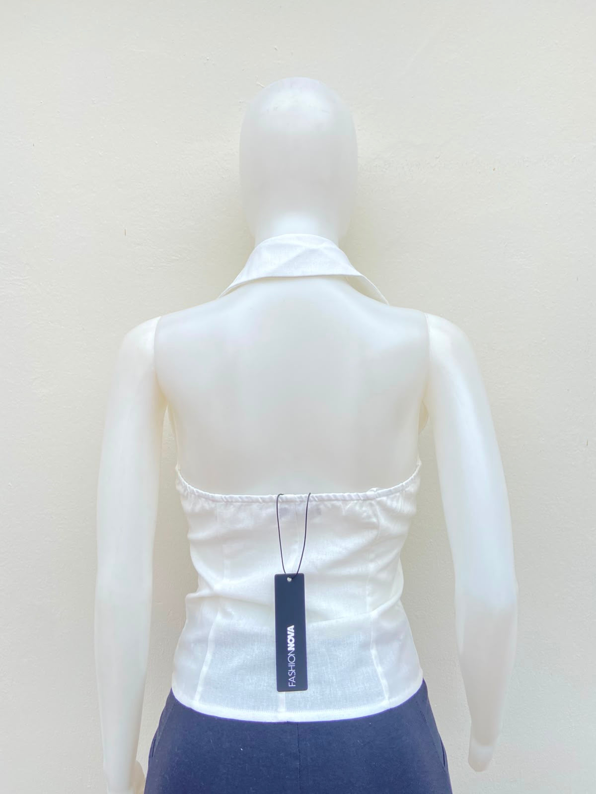 Top blanco con cuello estilo camisa, descostado atras.