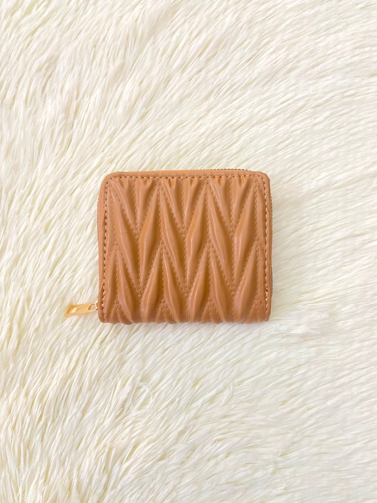 Monedero color marrón con diseño acolchado, cierre de zíper y espacio para tarjetas y más.