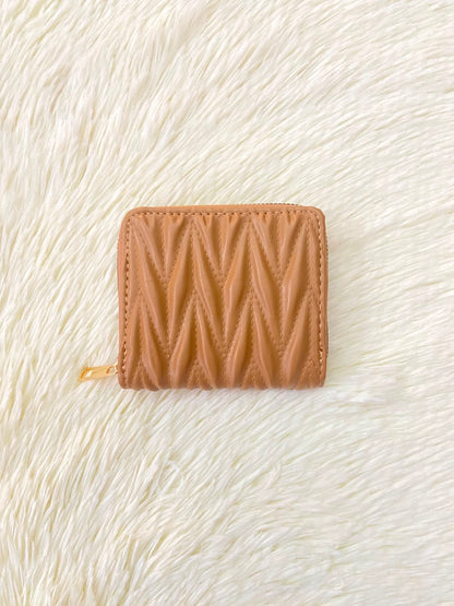 Monedero color marrón con diseño acolchado, cierre de zíper y espacio para tarjetas y más.