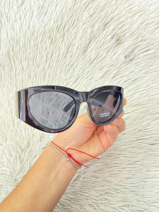 Lentes negros con detalles en color dorados y micas oscuras