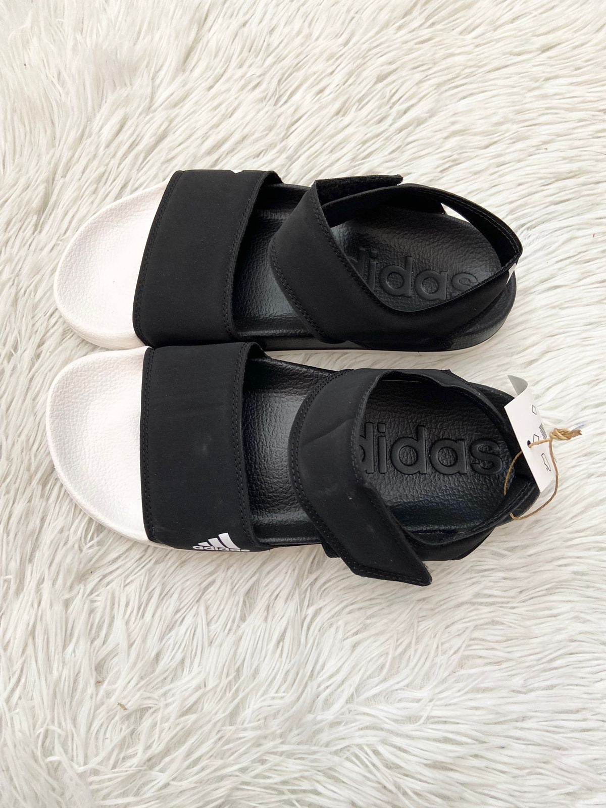 Sandalias ADIDAS original, negras con letras y logotipo de la marca en un lado de color blanco.