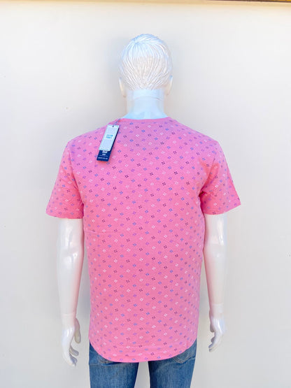 T-shirt MBX PREMIUM GOODS original, en color rosado claro con estampado de pequeñas figuras geométricas en color morado, azul negro y blanco, 100% algodón