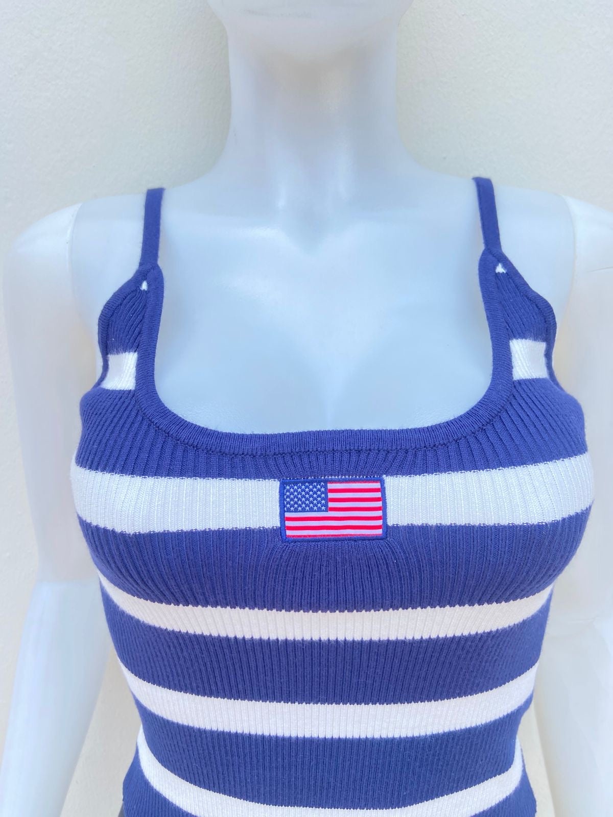 Top, azul marino con rayas en color blanco y bandera de USA en frente.