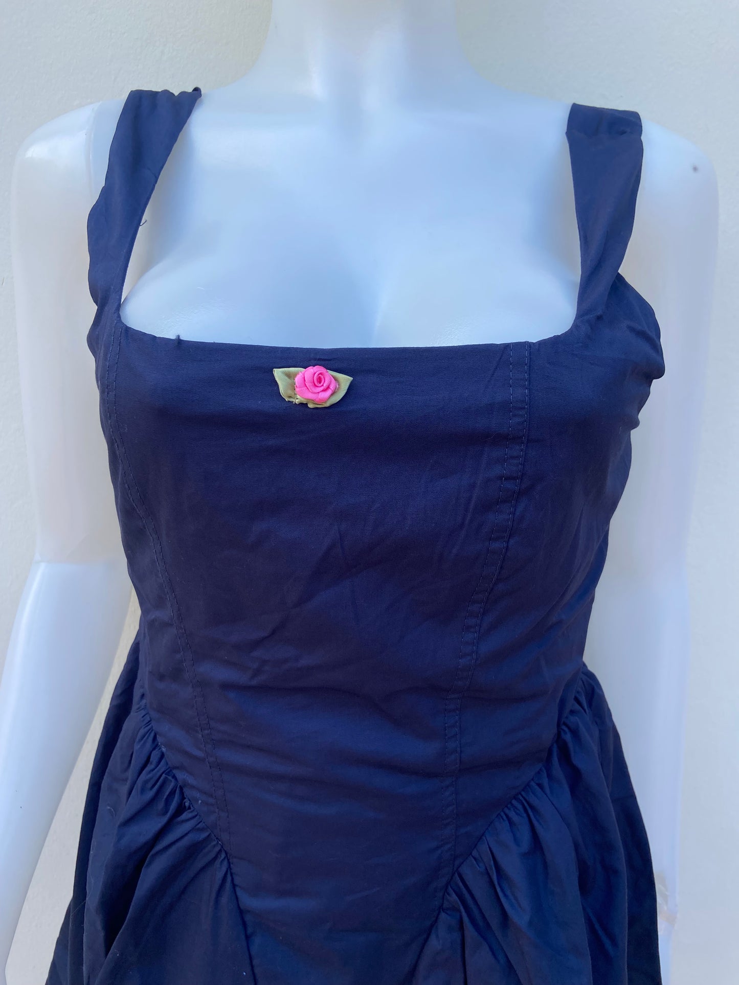 Vestido, algodón orgánico en azul marino ( NAVY) con flor rosada en frente.