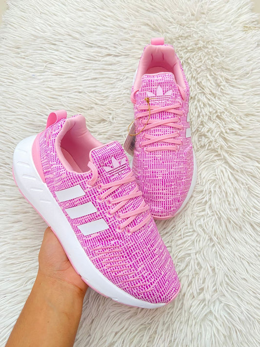 Tenis Adidas original rosado con blanco y logotipo de la marca en frente y líneas blancas en los costados.