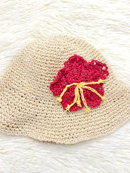 Sombrero, color crema y tejido artesanal estilo lana con flor roja con amarillo.
