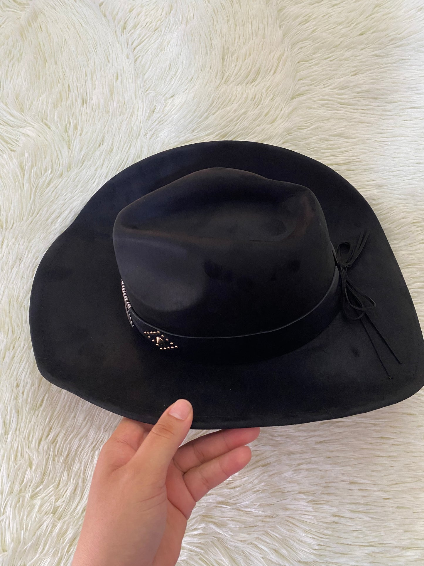 Sombrero, negro con detalles de hilos blancos y detalle de puntos dorados.