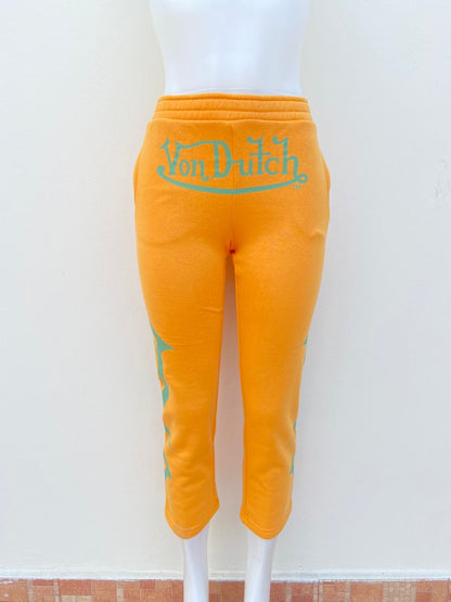 Pantalon VON DUTCH original Amarillo mostaza con letras de la marca en verde.