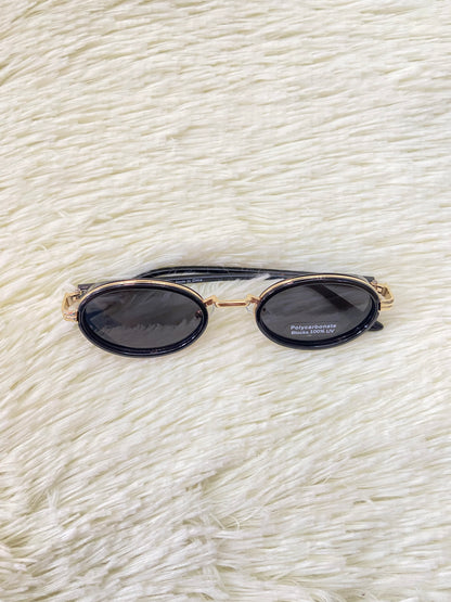 Lentes, negros con montura dorada ovalados, con protección UV 100% Polycarbonate.