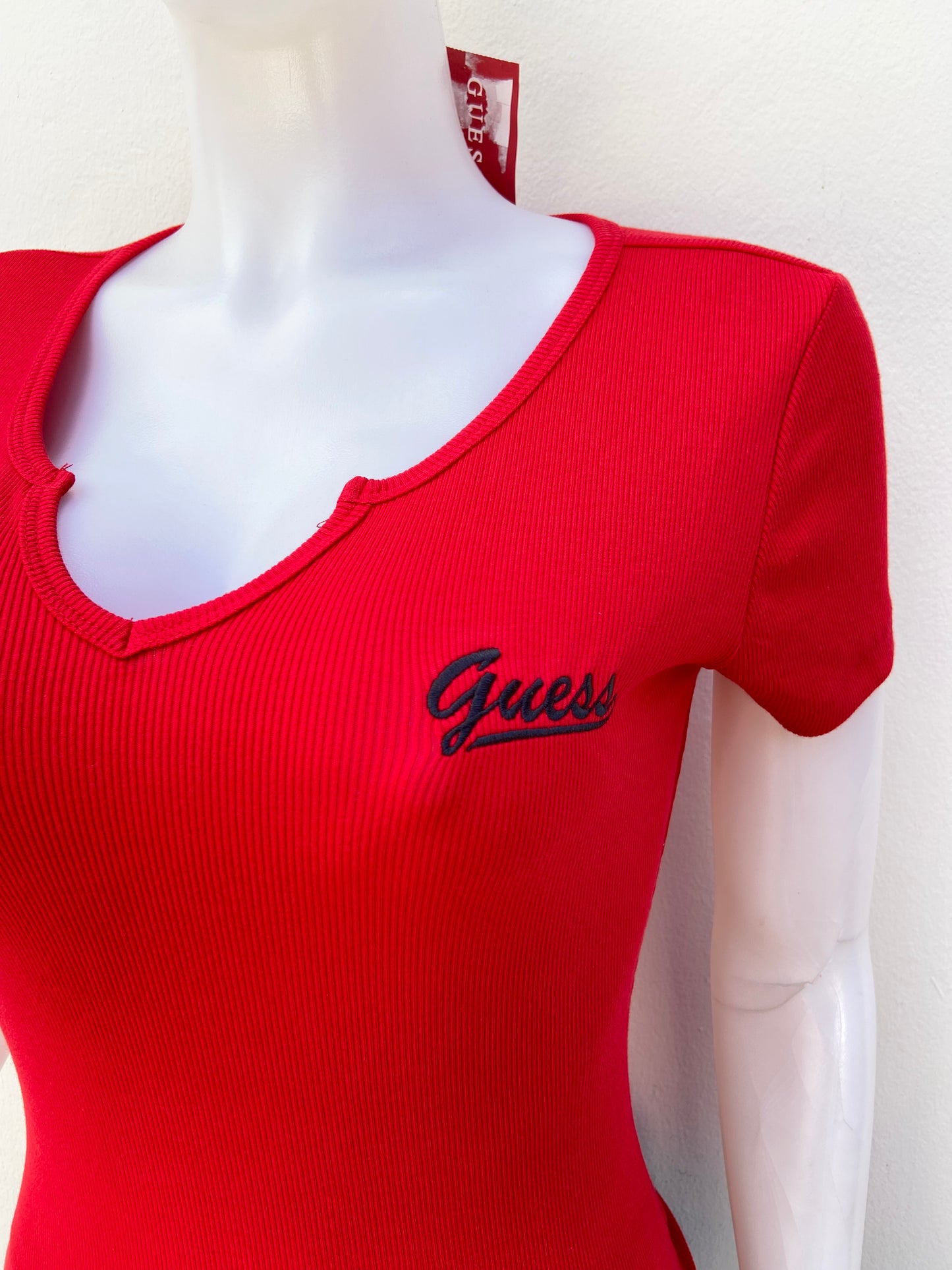 T-shirt GUESS original, rojo liso con letras GUESS en cursivas en color negro, con cuello V.