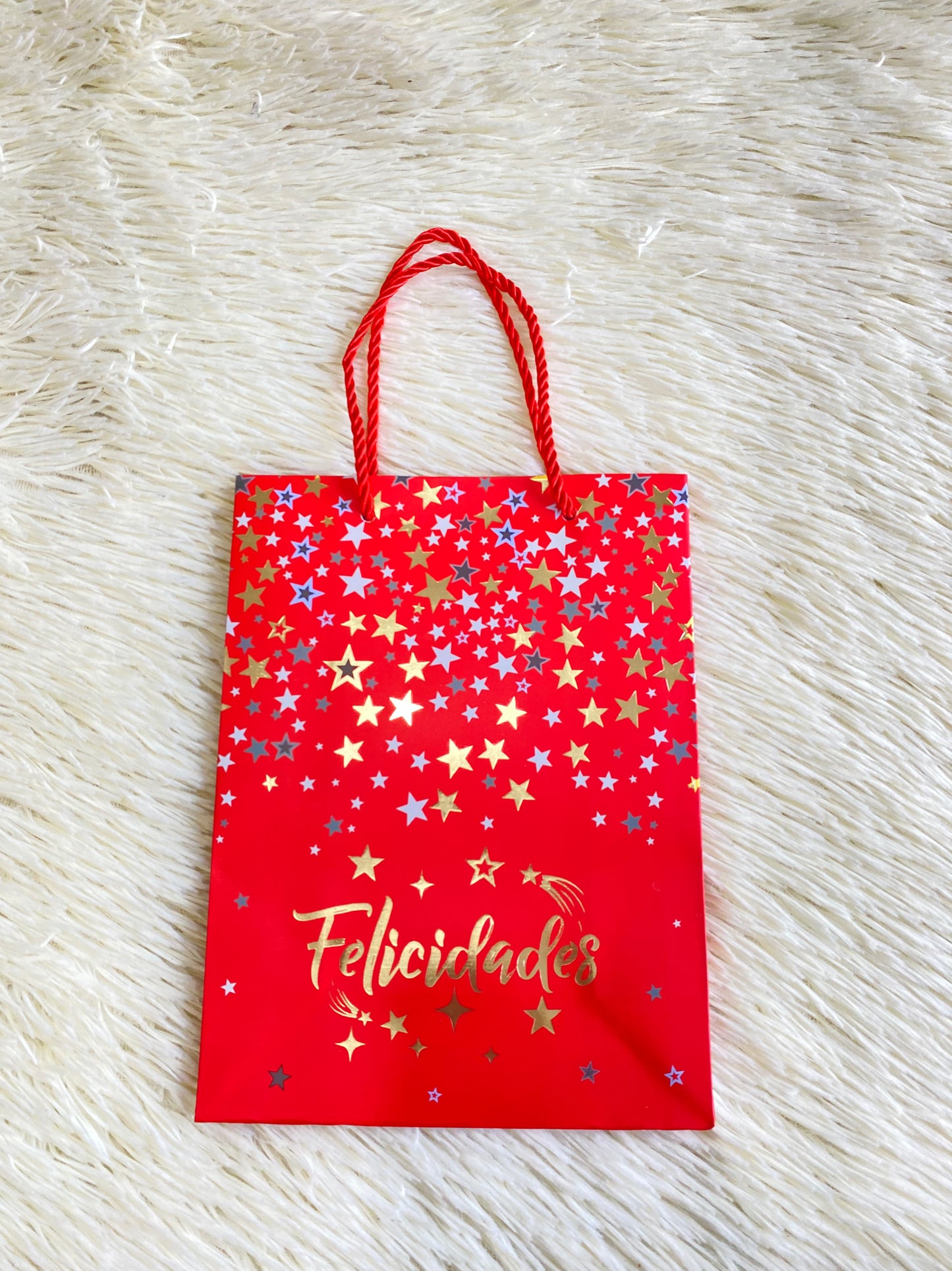 Shopping rojo con estrellas amarillas y azul con letras felicidades debajo. PEQUEÑO