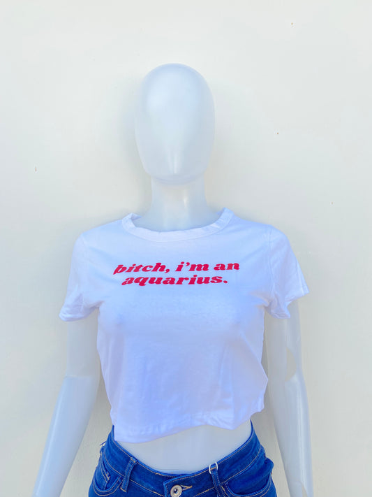 Top, blanco con letras BITCH I’M AN AQUARIUS ( Perra, soy acuario ) en rojo.