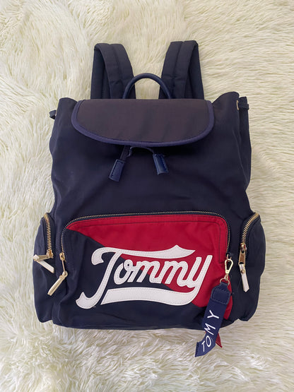 Mochila Tommy Hilfiger original en color azul marino, nombre TOMMY en grande en un bolsillo con el fondo rojo, varios compartimentos, súper espacioso.