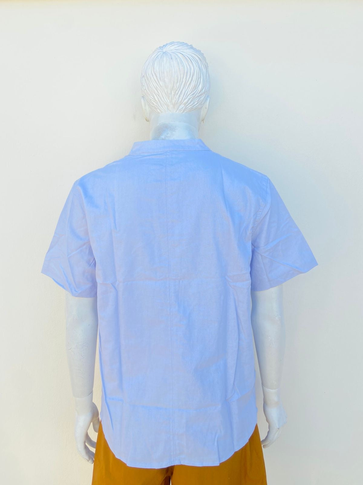 Camisa en color azul claro, manga corta y cuello mandarin.