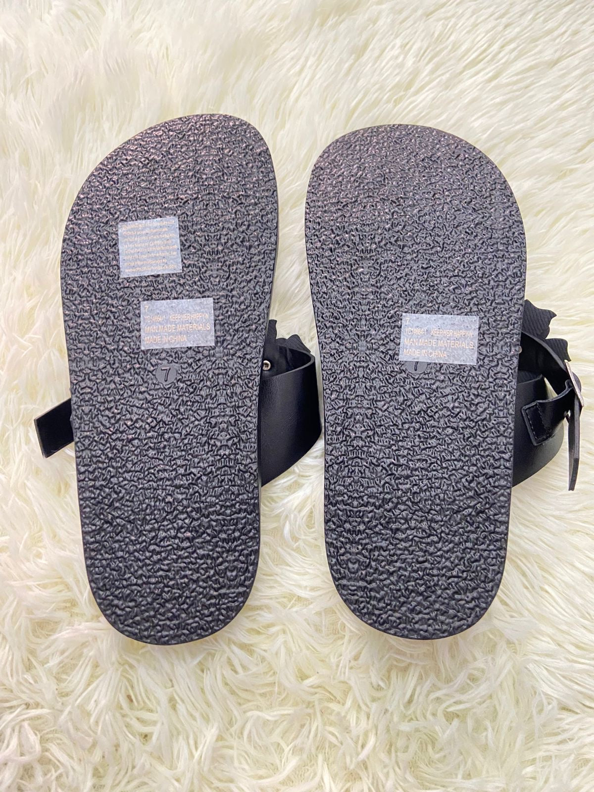 Sandalias, negra con flores en frente y correa ajustable.