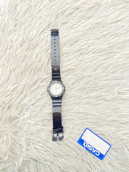 Reloj Casio original negra con fondo en color blanco y verde.