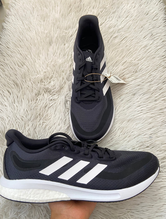 Tenis Adidas original negro con logotipo de la marca en frente y suelas blancas.