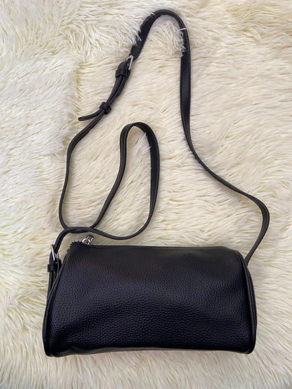 Cartera, negra pequeña con lazo ajustable, en forma de cilindro.