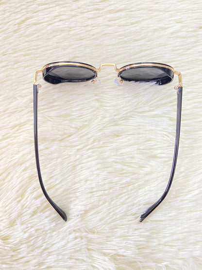 Lentes, negros con montura dorada ovalados, con protección UV 100% Polycarbonate.